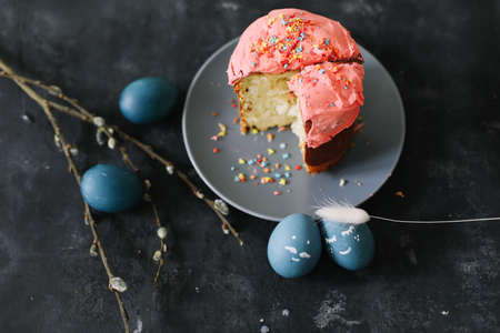 Easter cake, colorful eggs and willow branches on dark background. Happy Easter holiday concept