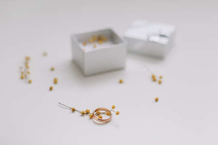 Box with golden engagement ring on flowers background, top view. Wedding, Marriage proposal concept