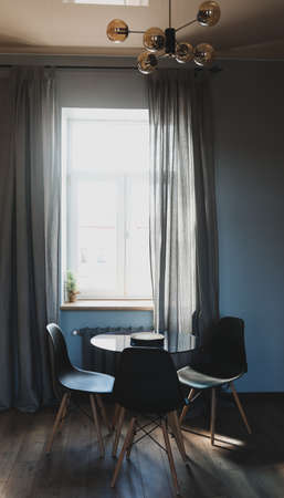 Stylish dining room with modern chairs and table by the windowの写真素材