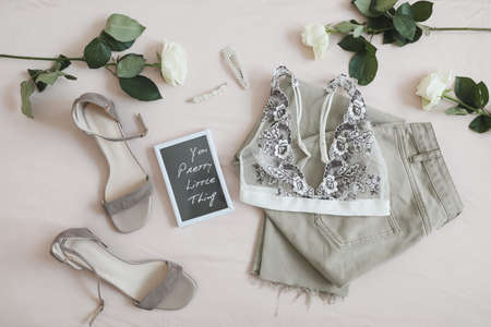 Women jeans, sandals, lingerie and flowers top view. Womens stylish spring summer outfit. Trendy clothes. Flat lay.の写真素材