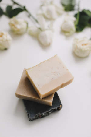 Handmade natural soap on white floral background. Soap making. Soap bars. Spa, skin care. Natural Organic spa cosmetic products on white table from aboveの写真素材