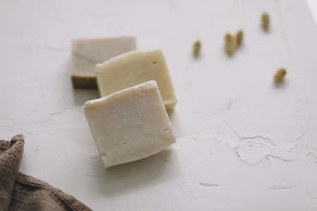 Handmade natural soap on white floral background. Soap making. Soap bars. Spa, skin care. Natural Organic spa cosmetic products on white table from aboveの写真素材