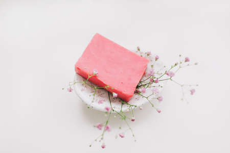 Natural handmade soap bar with ceramic soap dish and flowers, spa organic soap, sustainable lifestyleの写真素材