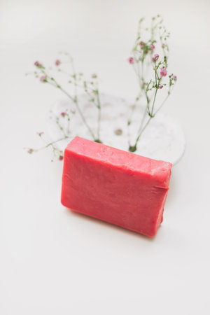 Natural handmade soap bar with ceramic soap dish and flowers, spa organic soap, sustainable lifestyleの写真素材