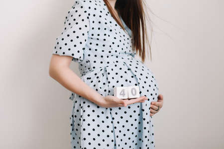 40 weeks of pregnancy. Pregnant woman touching belly. Happy woman pregnancy, maternity, body care. Expecting an upcoming babyの写真素材