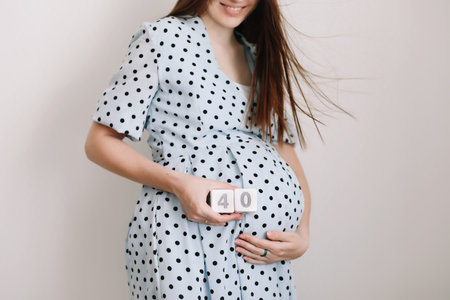 40 weeks of pregnancy. Pregnant woman touching belly. Happy woman pregnancy, maternity, body care. Expecting an upcoming babyの写真素材
