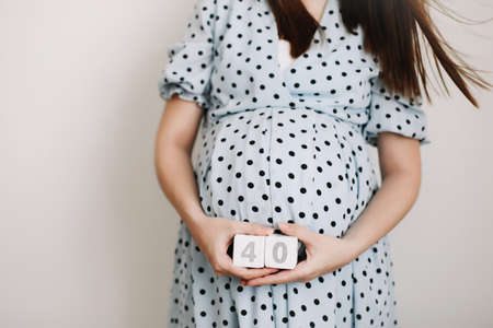 40 weeks of pregnancy. Pregnant woman touching belly. Happy woman pregnancy, maternity, body care. Expecting an upcoming babyの写真素材