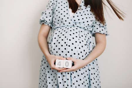 40 weeks of pregnancy. Pregnant woman touching belly. Happy woman pregnancy, maternity, body care. Expecting an upcoming babyの写真素材