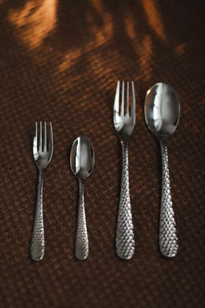 silver stainless cutlery on a dark fabric backgroundの写真素材