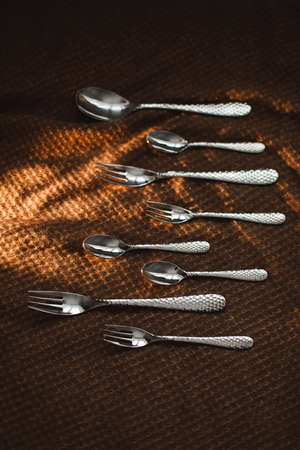 silver stainless cutlery on a dark fabric backgroundの写真素材