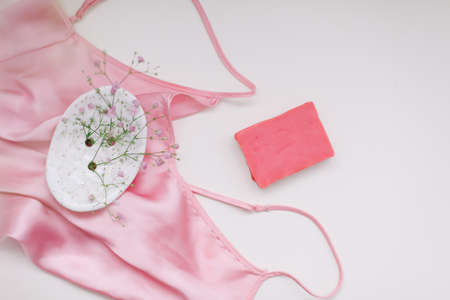 Spa composition with pink soap bar with ceramic soap dish, silk babric and flowersの写真素材