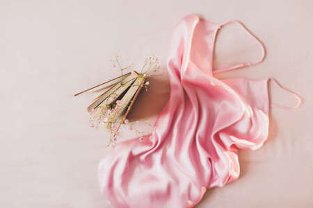 Romantic composition with a book, flowers and silk fabric. Flat lay, top view, mock upの写真素材