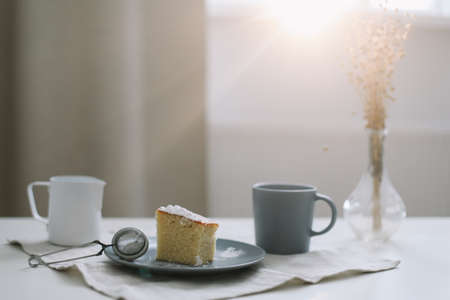 Morning breakfast with a piece of fresh homemade cake, pitcher and cup of coffee on a tableの写真素材