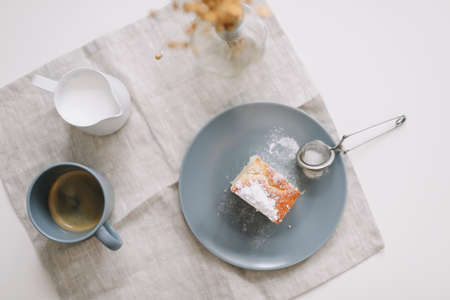Morning breakfast with a piece of fresh homemade cake, pitcher and cup of coffee on a tableの写真素材