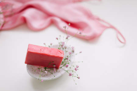 Handmade natural soap on white floral background. Soap making. Soap bars. Spa, skin care. Natural Organic spa cosmetic products on white table from above.の写真素材