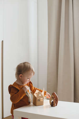 Little girl playing with eco-friendly wooden toys. Home activities for kids