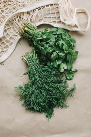 Bunches of fresh greens in eco-bag. Organic healthy food background. Flat lay, top view, copy space....