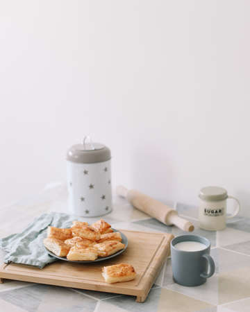 freshly baked homemade pastry on kitchen table. breakfast with puff buns and a glass of milkの写真素材