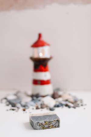 A small decorative lighthouse with sea shells and pebbles.の写真素材