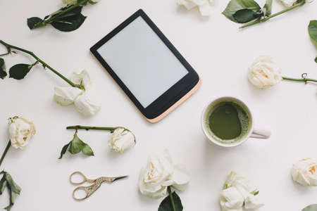 Floral composition with tablet, roses on white background. Flatlay, top view. Copy space mockup template.の写真素材