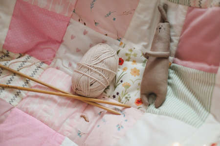 Cozy homely background with wool yarn and knitting needles on an armchair with a blanket.の写真素材
