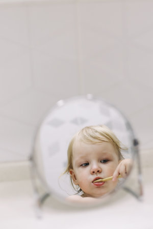 little funny girl brushing her teeth in the bathroomの写真素材