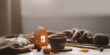 Autumn still life details in cozy home interior with a cup, candles, plaid. Hygge home decor. Thanksgiving conceptの写真素材