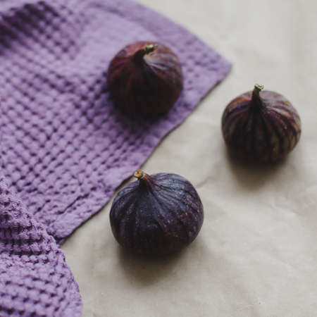 ripe fresh figs and purple textiles on rustic background, flatlay, overhead viewの写真素材