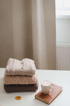 cozy comfortable autumn and winter home atmosphere and still life with a cup, candle, book and sweatersの写真素材