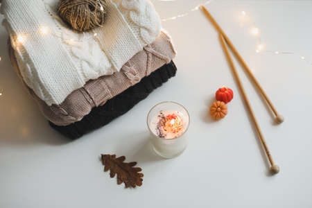 cozy winter and autumn composition with needles, knitted clothes and a candle, top viewの写真素材