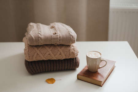 cozy comfortable hygge home atmosphere and still life with a cup, candle and sweatersの写真素材