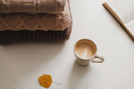 cozy comfortable winter and autumn home atmosphere and still life with a cup, book and warm sweatersの写真素材