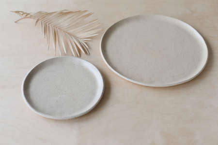 Ceramic plate on a wooden table top view. minimalist handmade ceramic tableware and pottery