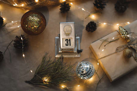 Christmas composition. New Year eve. December 31 on calendar on a craft paper background with spruce branches and a glowing garland. New years date. Flat lay, top viewの写真素材