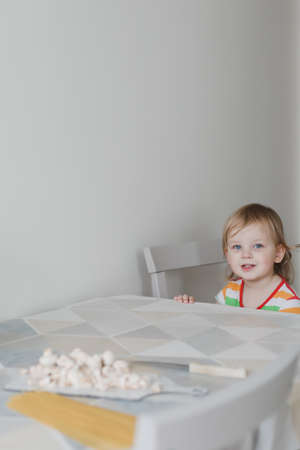 funny little girl cooking pasta in the kitchenの写真素材