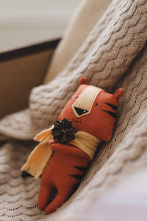 Funny small tiger toy, symbol of new 2022 on beige background. Crochet stuffed animals.の写真素材