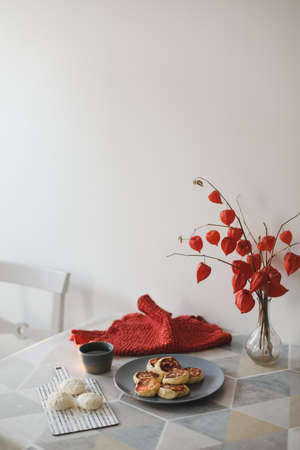 breakfast with homemade cottage cheese pancakes, a cup of tea and flowers in a vase on the tableの写真素材