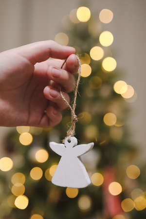 Decorating Christmas tree, holding Christmas toy in a hand. Holiday, Christmas and New Year family celebration conceptの写真素材