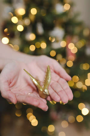 Decorating Christmas tree, holding Christmas toy in a hand. Holiday, Christmas and New Year family celebration conceptの写真素材