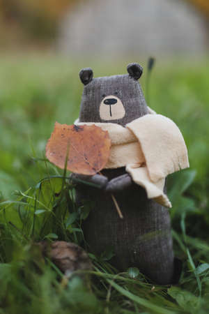 Cute little handmade toy teddy bear in green grass. Childhood, baby, holiday, people, hobby, emotions conceptsの写真素材