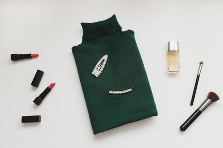 Overhead view of womens knitted sweater, perfume and accessories on white background. Flat lay, top view. Stylish women clothesの写真素材