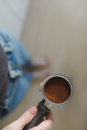 Barista makes coffee and holds portafilter in hands from a coffee machine. Close-upの写真素材