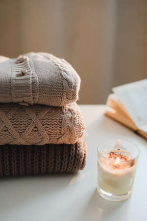 cozy home atmosphere and still life with coffee, candle and sweatersの写真素材