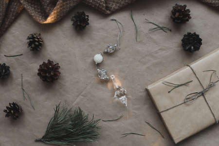 Christmas composition. Gift, fir tree branches, balls on paper background. Christmas, winter, new year concept. Flat lay, top view, copy spaceの写真素材