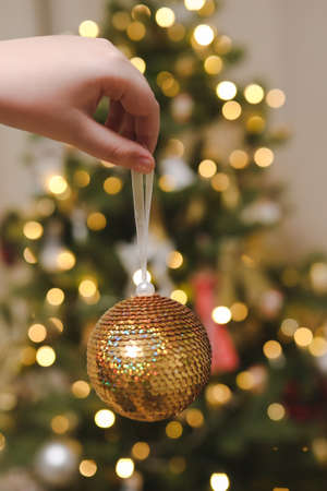 hand holding toy and decorating Christmas tree. Holiday, Christmas and New Year celebration conceptの写真素材