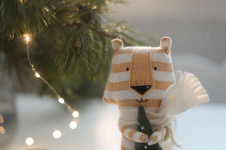cute soft toy tiger with decorations on a cozy Christmas or New Year background. symbol of 2022, oriental calendar conceptの写真素材