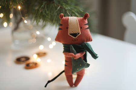 cute soft toy tiger with decorations on a cozy Christmas or New Year background. symbol of 2022, oriental calendar conceptの写真素材