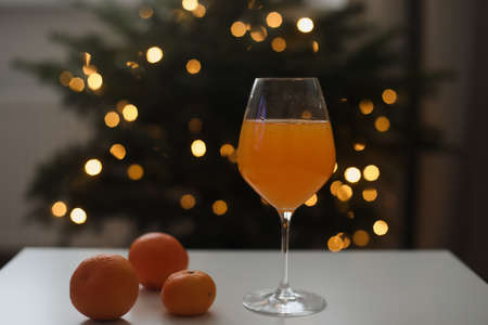 tangerine or orange juice with tangerines on the Christmas tree backgroundの写真素材
