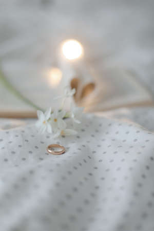 Golden ring and open book with folded sheets in heart shape in bed. Wedding concept, Happy Valentines Dayの写真素材