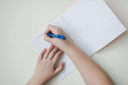 pupil's hands writing in open notebook, top view, copy space.の写真素材